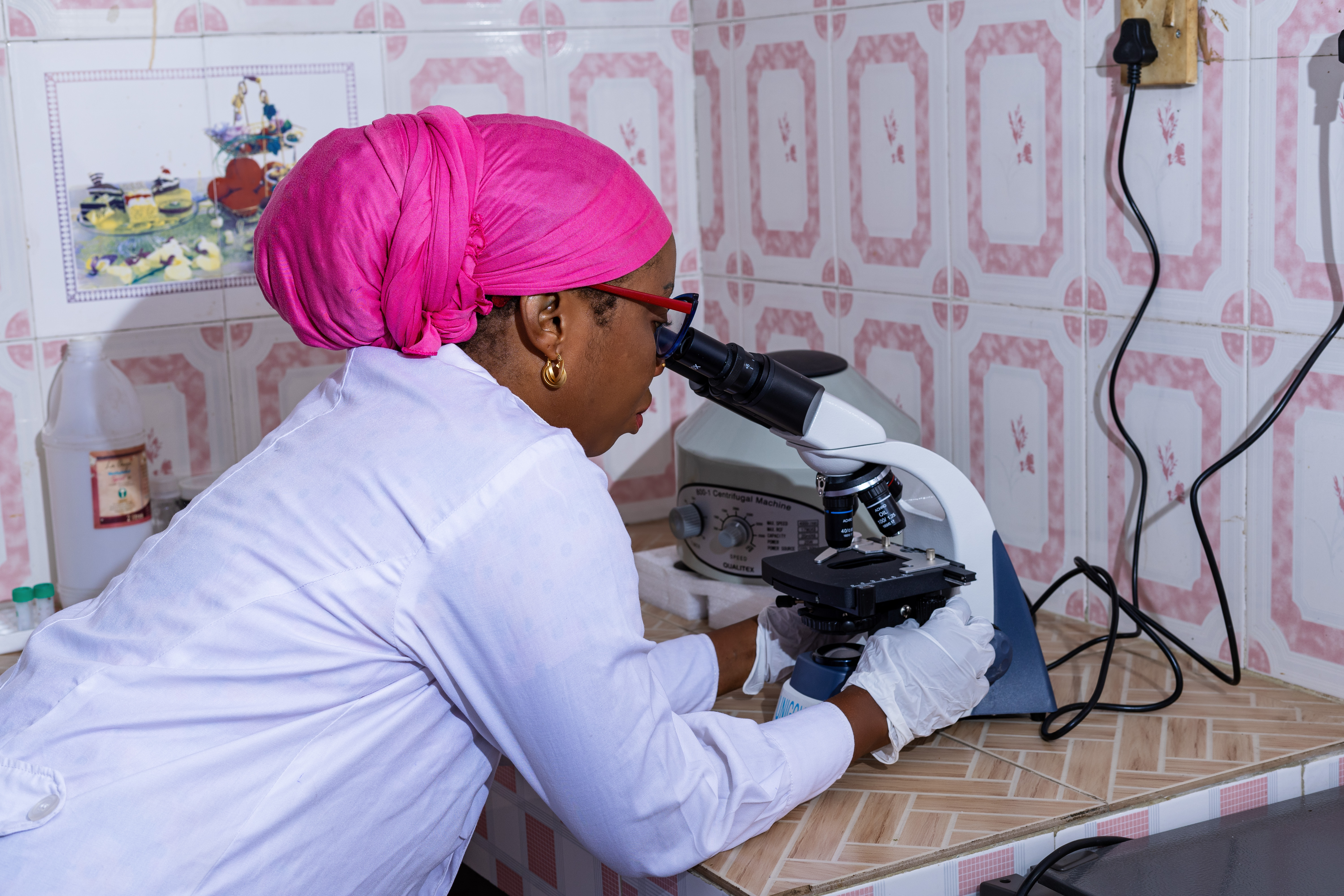 Laboratory technician analysing samples under a microscope