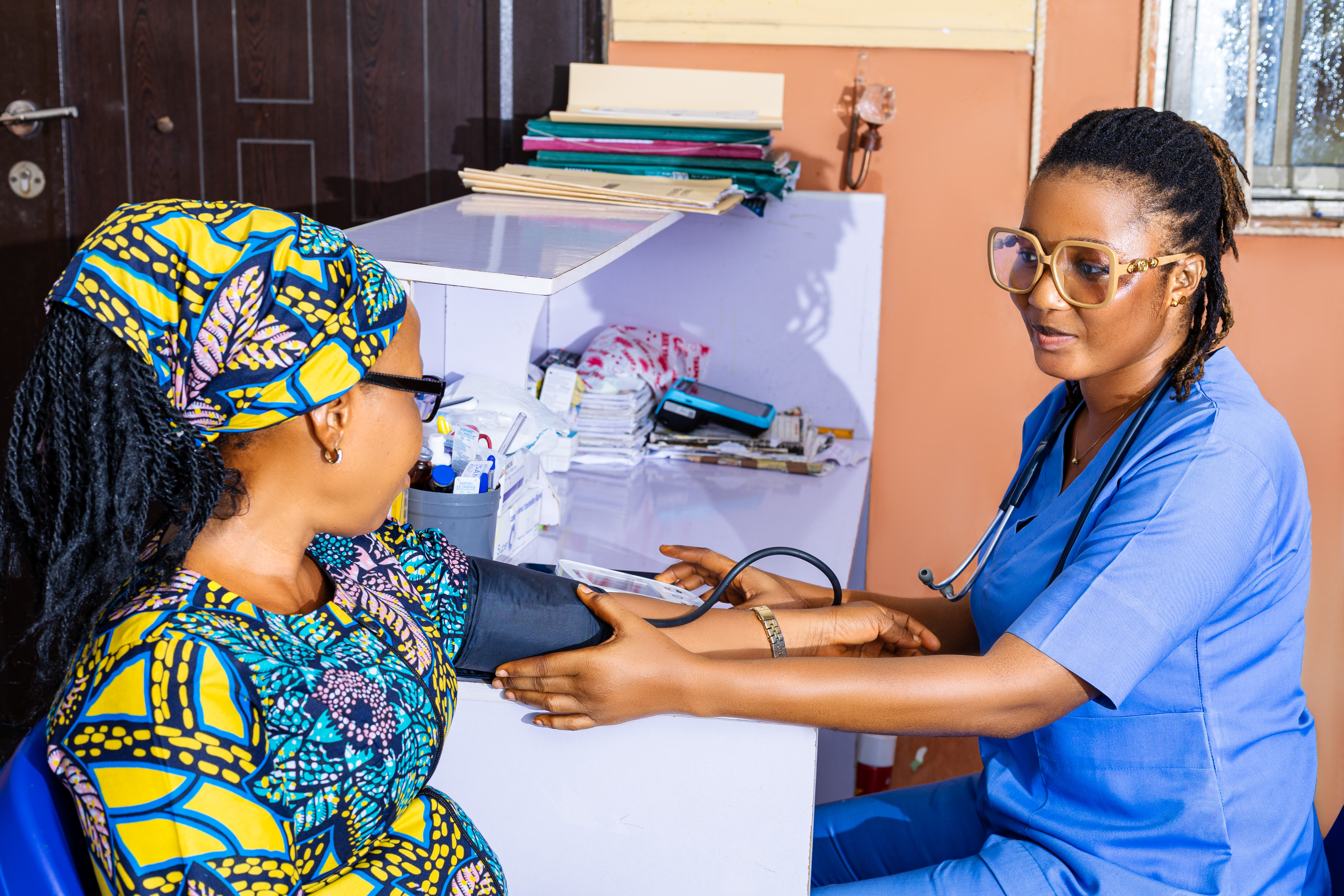 Reception area of a modern hospital with a nurse assisting a patient